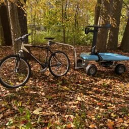 A bike with a wagon attached using the bike attachment accessory from Kahuna Wagons, in the woods surrounded by leaves.