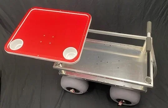 A red and white tabletop with cupholders, attached to a Kahuna Wagon with beach balloon tires.