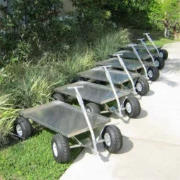 Several Kahuna Wagon Heavy Duty Jupiter Pull Wagons lined up outside on a sidewalk and grassy area.